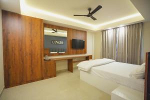 a bedroom with a bed and a ceiling fan at Hotel ASG Grand in Ranipet