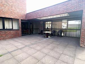 a brick building with a patio with a table at Sophia-Elvira in Diksmuide +1 photo