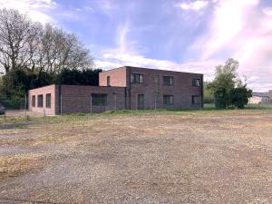 an old brick building sitting in a field at Sophia-Elvira in Diksmuide