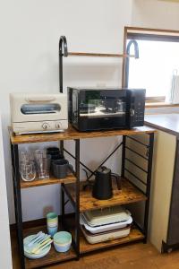 a microwave and a toaster oven on a shelf at Kokonimo Yotsukaido in Yotsukaidō