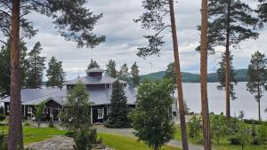 a house on the shore of a lake with trees at Boutique Hotelli Kivennapa in Pieksä +31 photos