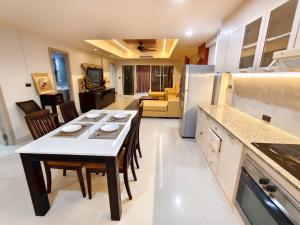 a kitchen and living room with a table and chairs at 3-bedroom apartment, Patong, Palm Spring 602 in Patong Beach