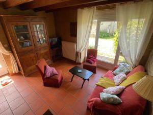 a living room with a couch and chairs and a window at Manoir La Bordeneuve in Villeneuve-sur-Lot