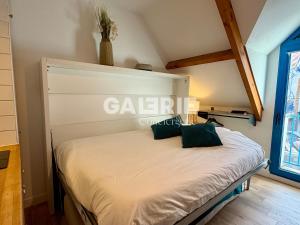a bedroom with a white bed with green pillows at GC - Au Gré Du Vent in Wissant