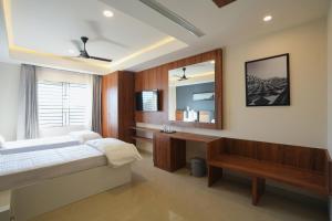 a bedroom with a bed and a desk and a mirror at Hotel ASG Grand in Ranipet