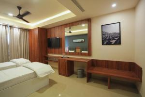 a bedroom with a bed and a desk and a mirror at Hotel ASG Grand in Ranipet