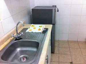 a kitchen counter with a sink and a refrigerator at Departamento Miraflores in Lima