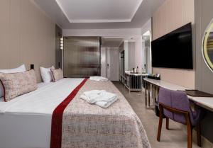 a hotel room with a large bed and a desk at Side Alegria Hotel & Spa - All Inclusive-Adult Only in Side +59 photos