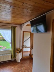 a living room with a flat screen tv on a wall at Andrea Vendégház in Izvoru Mureşului