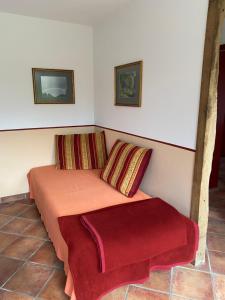 a bed with two pillows and a red blanket at Wassermühle in Rheine