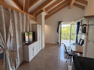 a living room with a television and a dining room at HotelPension Weberhof in Ebersberg