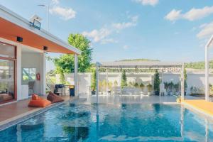a swimming pool in front of a house at KN Pool Villa Saraburi in Ban Huai Sai (1)
