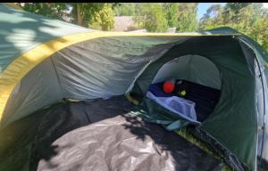 a green tent with the door open with a person inside at Tentu Tentu, Babushtent in Ventspils