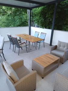 a patio with a wooden table and chairs at Studio Apartmani Kaja i Iva in Sinj