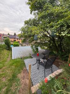 a patio with a table and chairs on a rug at Morgenstond in Groesbeek