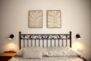 two framed pictures hang above a bed in a bedroom at La Placita in Caudiel