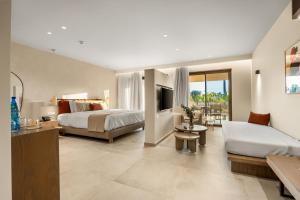 a hotel room with two beds and a living room at ARATO by E-GEO, Adults Only in Kos