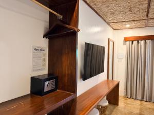 a room with a tv and a wooden shelf at Yumi Villas in San Vicente
