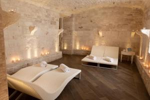 two beds in a room with lights on the wall at Relais Il Santissimo in Turi