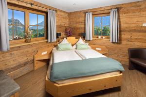 a bedroom with a bed and a desk and windows at Ferienwohnung Roislerlehen in Bischofswiesen