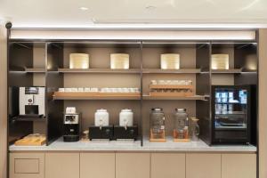 a display case in a kitchen with dishes on shelves at JI Hotel Beijing Xizhimen in Beijing