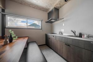 a kitchen with a counter and a sink and a window at Rusutsu Backcountry Lodge in Kimobetsu