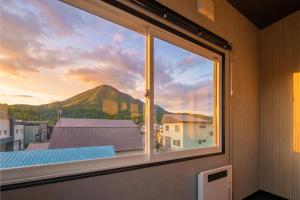 a window with a view of a mountain at Rusutsu Backcountry Lodge in Kimobetsu