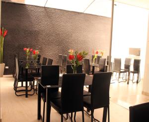 een eetkamer met tafels en stoelen en rode bloemen bij Hotel Radel Superior in Bogota