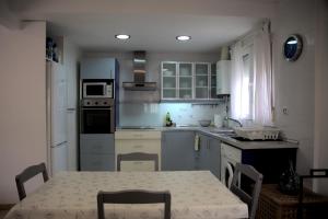 a kitchen with a table and a kitchen with white cabinets at La Placita in Caudiel