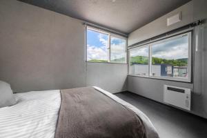 a bedroom with a bed and a large window at Rusutsu Backcountry Lodge in Kimobetsu +75 photos