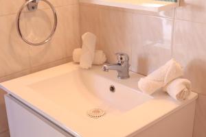 a bathroom sink with a towel dispenser on it at Summer Studios 2 in Koroni +15 photos