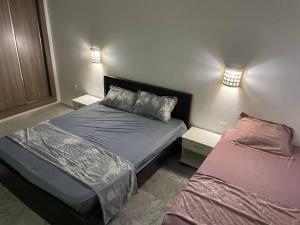 a small bedroom with two beds and two lamps at DarNejib, El Wafa City, Hammamet-Nabeul in Nabeul