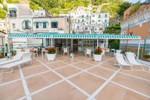 a patio with chairs and tables on a building at Amalfi Hotel centro storico in Amalfi