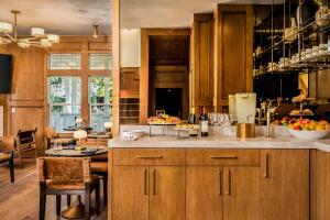 a kitchen with wooden cabinets and a table with a bowl of fruit at Polo House and Bungalows in Santa Ynez
