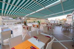 an outdoor restaurant with tables and chairs and a roof at Amalfi Hotel centro storico in Amalfi