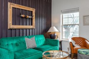 a living room with a green couch and a chair at Couples Condo Retreat Overlooking Golf Course in Branson West