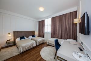 a hotel room with two beds and a television at Art Hotel in Split