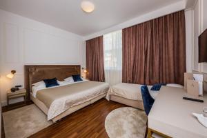 a hotel room with two beds and a desk at Art Hotel in Split