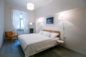 プラハにあるApartments At The Blue Ducklingの白いベッドルーム(ベッド1台、椅子付)