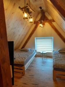 two beds in a attic room with wooden ceilings at BLUE Reset in Ruciane-Nida