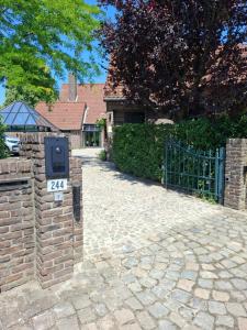 a brick fence with a mailbox next to a driveway at Pieters Huis in Kinrooi