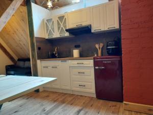 a kitchen with white cabinets and a red refrigerator at BLUE Reset in Ruciane-Nida +16 photos