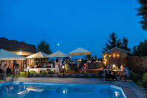 ein Garten mit Pool und abends ein Restaurant in der Unterkunft Hotel Rozkoš in Česká Skalice