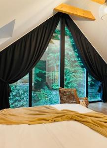 a bed in a room with a large window at Joli Chalet in Râşnov