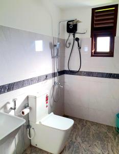 a bathroom with a shower and a toilet and a sink at Mahagedara Hiriketiya in Dickwella +17 photos