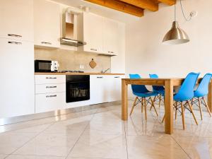 a kitchen with a wooden table and blue chairs at Appartamento Donà 2 in Rovigo