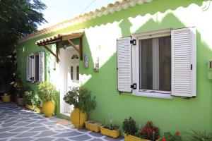 a green building with windows and potted plants at Summer Studios 2 in Koroni