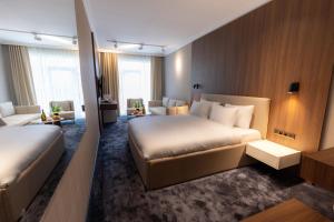 a hotel room with two beds and a couch at SOI Hotel & Casino in Svilengrad