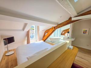 a bedroom with a large white bed and a sink at Hôtel L'orque Bleue in Sète