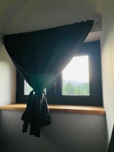 a window in a room with a curtain on a shelf at Joli Chalet in Râşnov